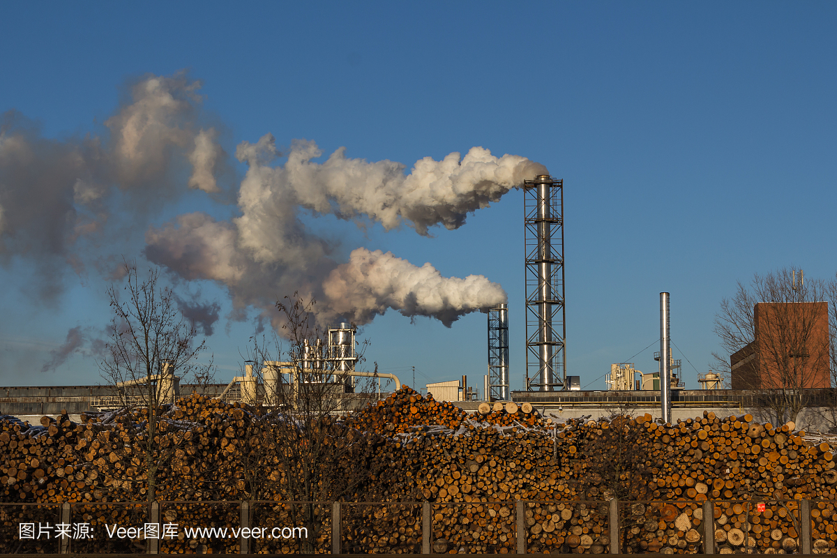 在蓝天的映衬下,一间木工工厂在抽着烟斗